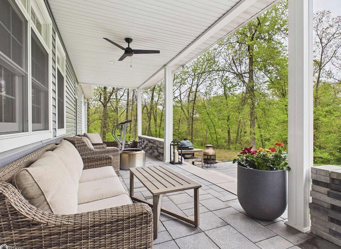 Cleaned covered back porch with wicker seating and ceiling fan