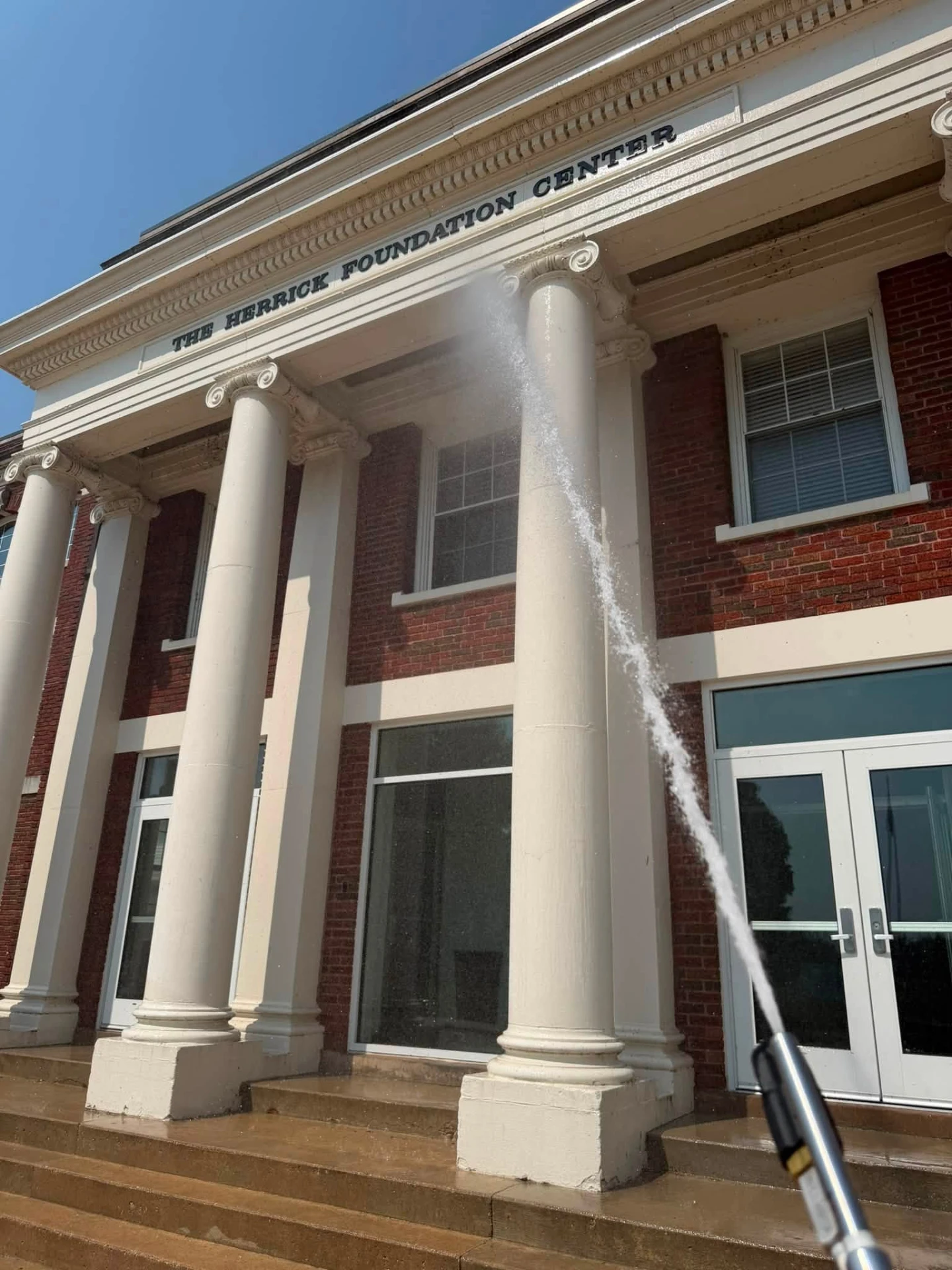 Pressure washing the columns of The Herrick Foundation Center